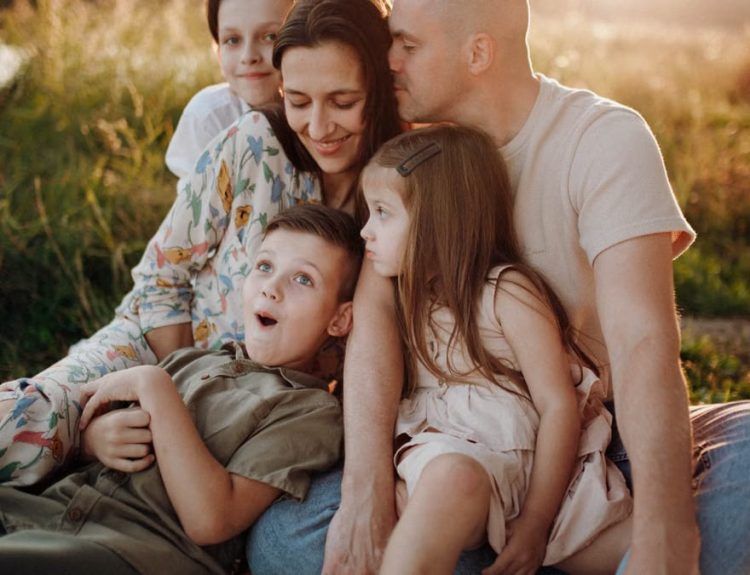 A joyful family enjoying quality time together on a sunset-lit meadow.